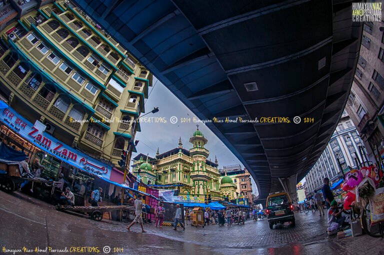 Bustling street view of Zam Zam Bakery and Minara Masjid on Mohammad Ali Road (Ebrahim Mohd Merchant Road), Mumbai — photographed by Humayunn Peerzaada.