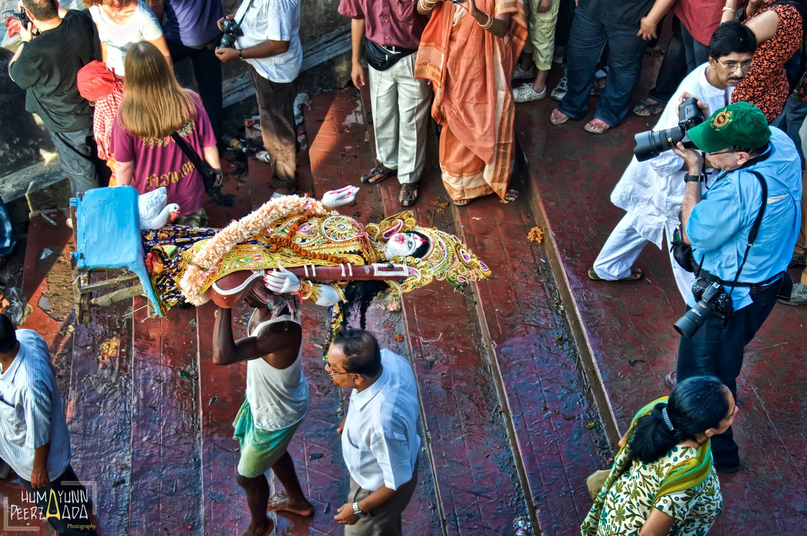 A devotee carrying a beautifully adorned idol of Goddess Durga during the immersion procession in Kolkata, West Bengal, as devotees gather to bid farewell on the occasion of Durga Visarjan.