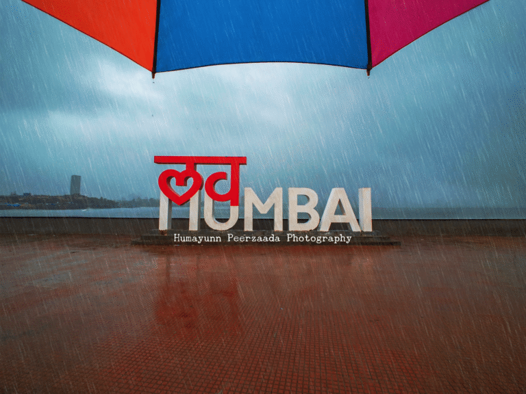 Rain-soaked streets of Mumbai with reflections of South Mumbai landmarks, captured during the monsoon season by Humayunn Peerzaada.