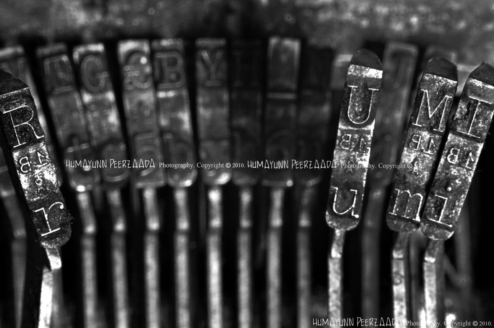 Close-up of vintage typewriter keys spelling out “Rumi,” symbolizing inspirations drawn from the poet’s timeless words.