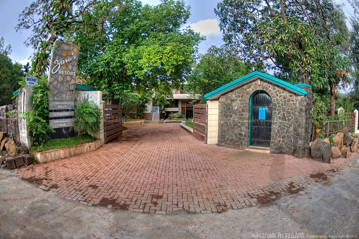 Entrance of Zara’s Resort in Khandala, featuring stone architecture, lush greenery, and a peaceful driveway that creates a welcoming ambiance.