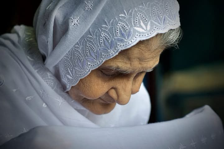 Aunt in a white headscarf, captured in a reflective and prayerful moment — remembered as a motherly figure embodying love, strength, and blessings.