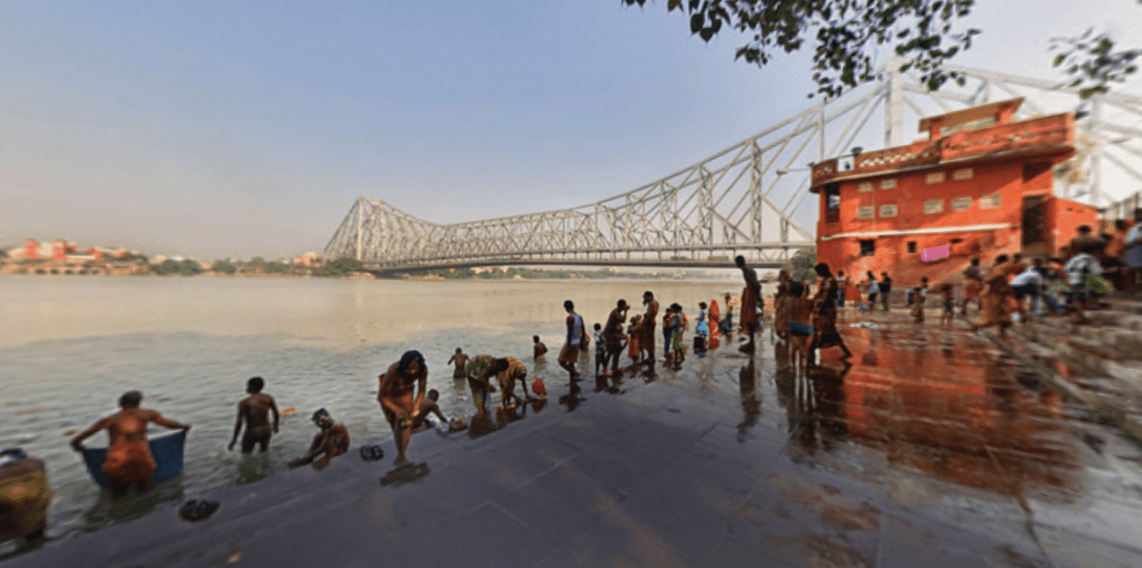 360° virtual panorama of the Howrah Bridge (Rabindra Setu) over the Hooghly River in Kolkata, West Bengal — shot from Mullick Ghat, showcasing boats, the river, and the iconic bridge under a vibrant sky.