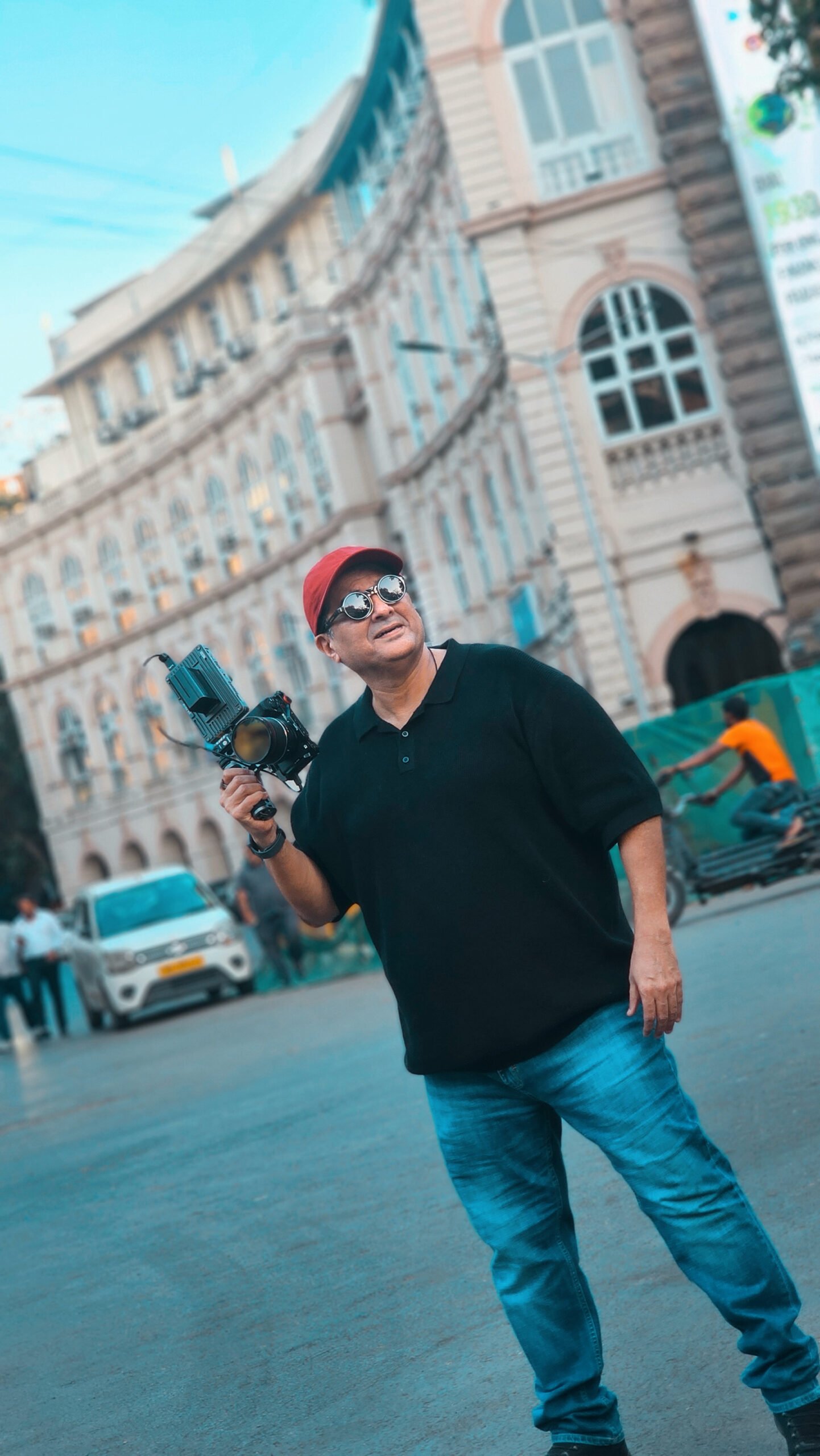 Photographer standing with camera in Mumbai street, symbolizing a lifelong connection with photography