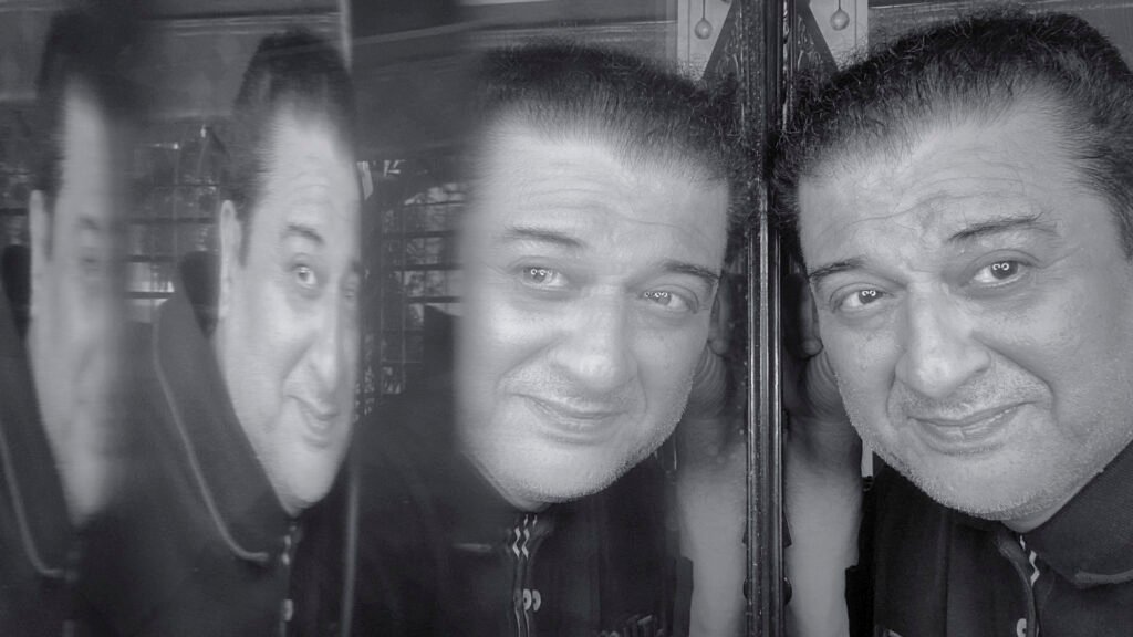 Black and white mirror self-reflection portrait of a man with multiple reflections, symbolizing life, emotions, and inner thoughts