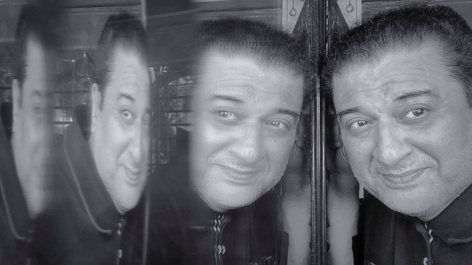 Black and white mirror self-reflection portrait of a man with multiple reflections, symbolizing life, emotions, and inner thoughts