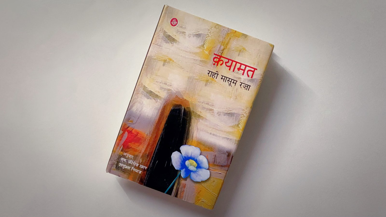 The Hindi edition of Qayamat by Dr. Rahi Masoom Raza, placed against a plain background, featuring an abstract cover design with a blue flower.